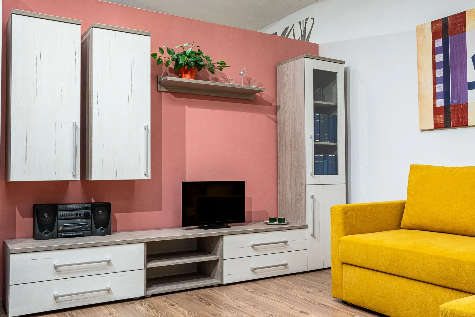 Světlá obývací stěna Excel 2 s růžovým pozadím a žlutou sedačkou